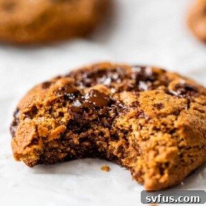 Close-up side view of a flourless chocolate chip cookie with a bite taken out