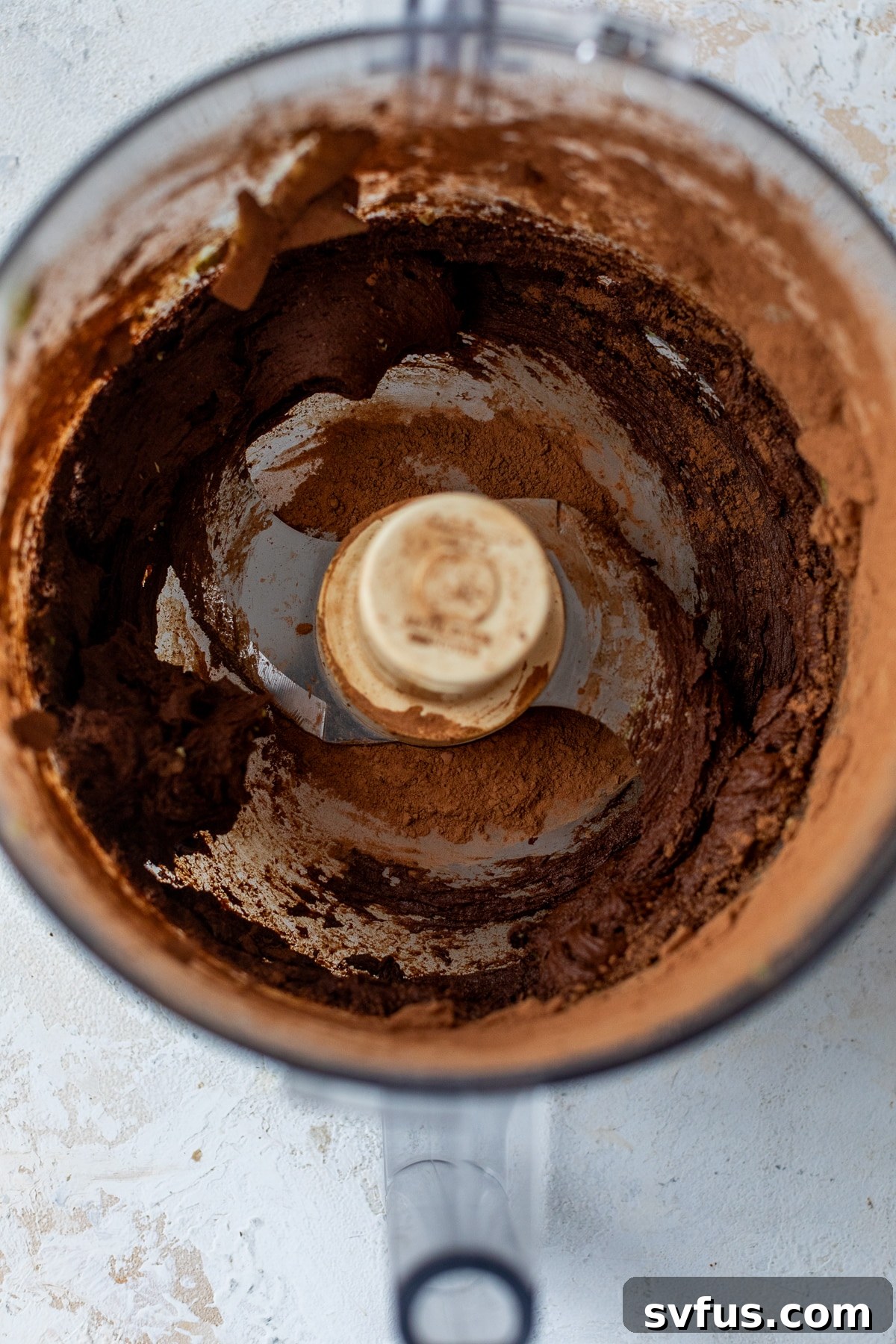 a smooth cocoa powder mixture in a food processor, showing the pudding in progress.