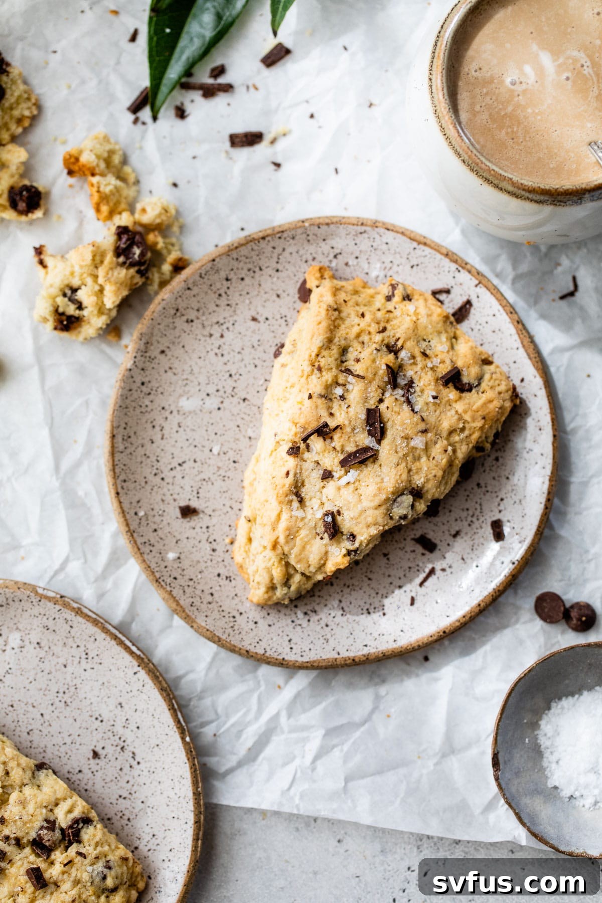 A perfectly baked vegan scone on a small plate, accompanied by a steaming mug of coffee, ready for a cozy moment.