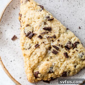 a scone on a plate topped with chopped chocolate