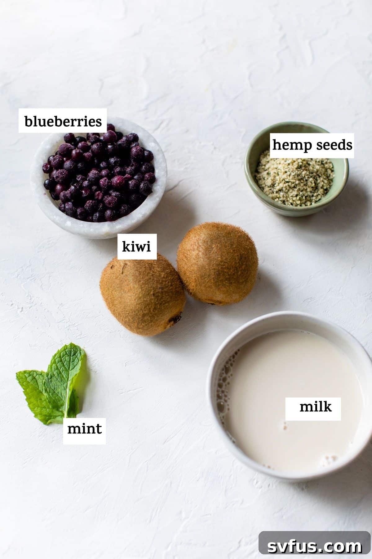 Fresh ingredients laid out for making the smoothie: kiwi, blueberries, and mint.