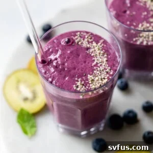 blueberry smoothie in a glass topped with hemp seeds