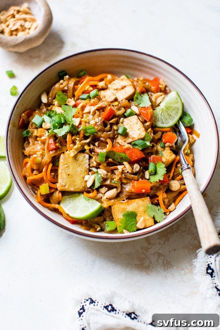 Noodles in a bowl with tofu and lime wedges