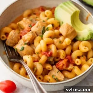 overhead view of a bowl of Chicken Fajita Pasta topped with sliced avocado.