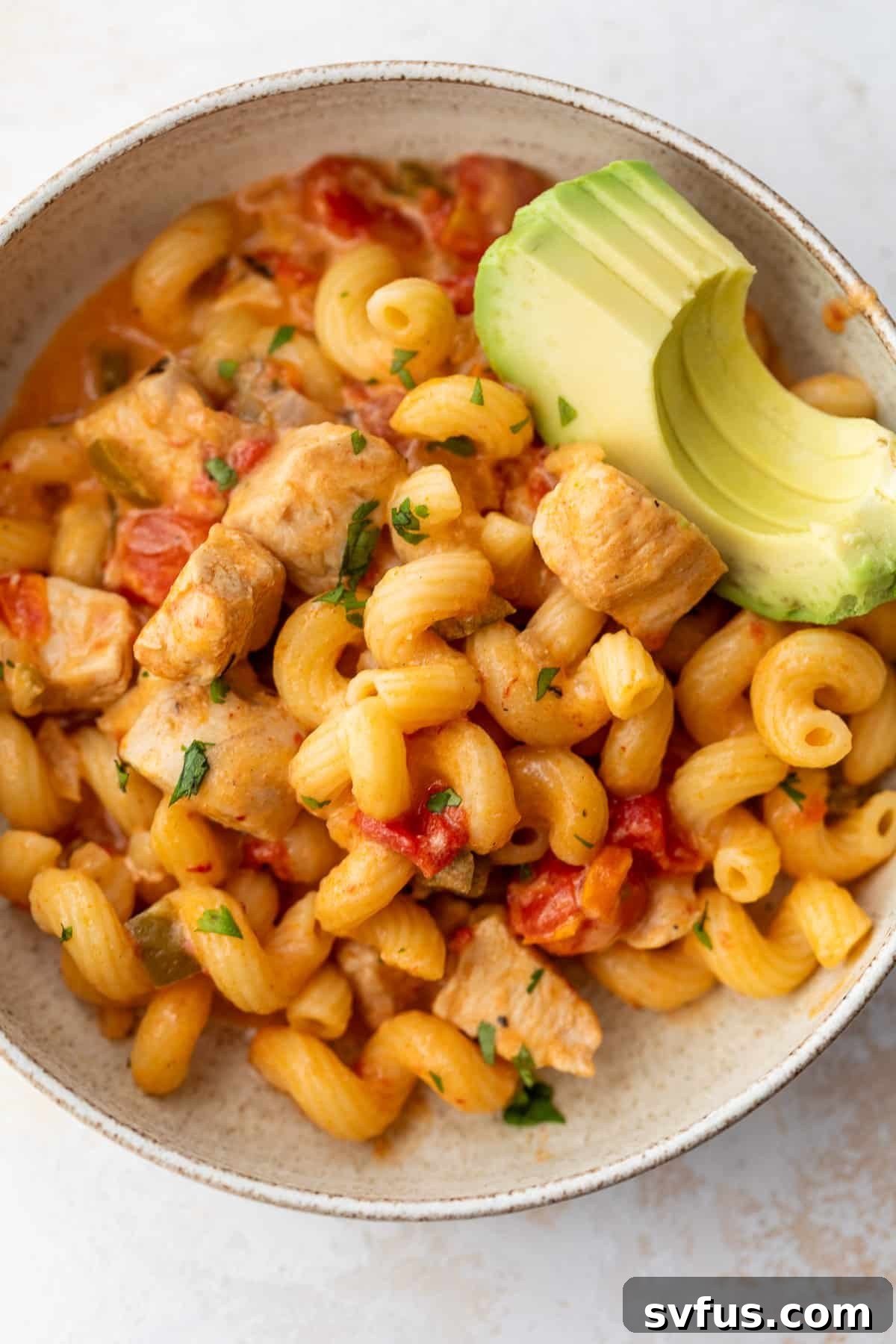 A vibrant close-up of Chicken Fajita Pasta in a large skillet, showing the perfectly cooked pasta, tender chicken, and colorful bell peppers coated in a rich, creamy sauce.