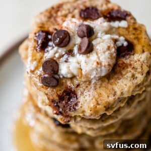 A stack of pancakes topped with vegan yogurt and chocolate chips, indicating a healthy and delicious breakfast.
