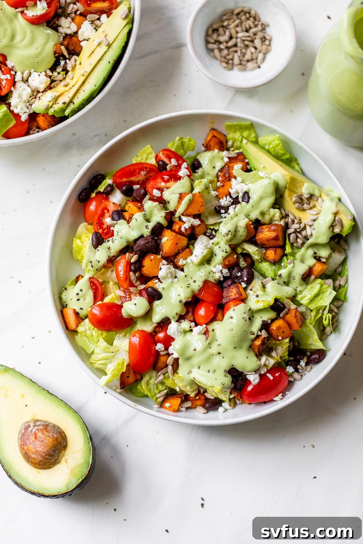 An overhead shot of a generous bowl of Southwest Sweet Potato Salad, expertly drizzled with green dressing and ready to be enjoyed.
