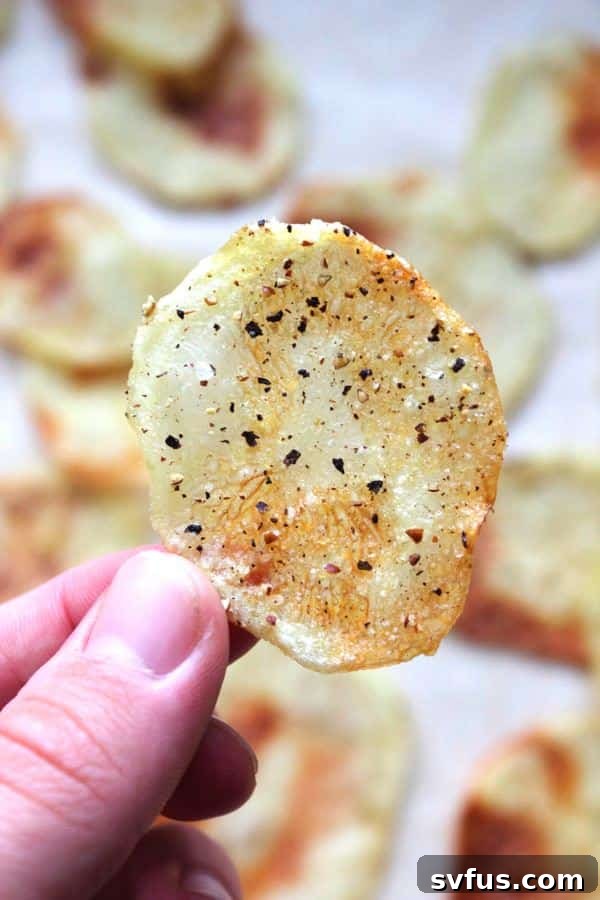 Thinly sliced potatoes ready to be seasoned for baking into salt and pepper chips