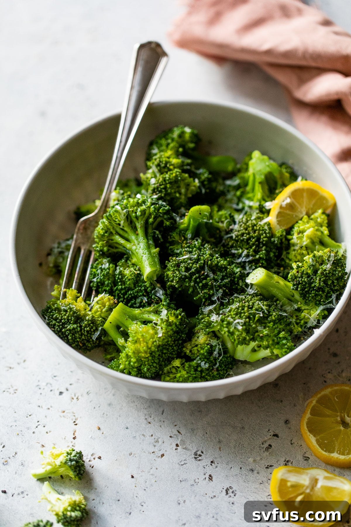 A vibrant bowl of perfectly cooked Instant Pot broccoli, accompanied by fresh lemon wedges, ready to be seasoned and garnished for a healthy meal.