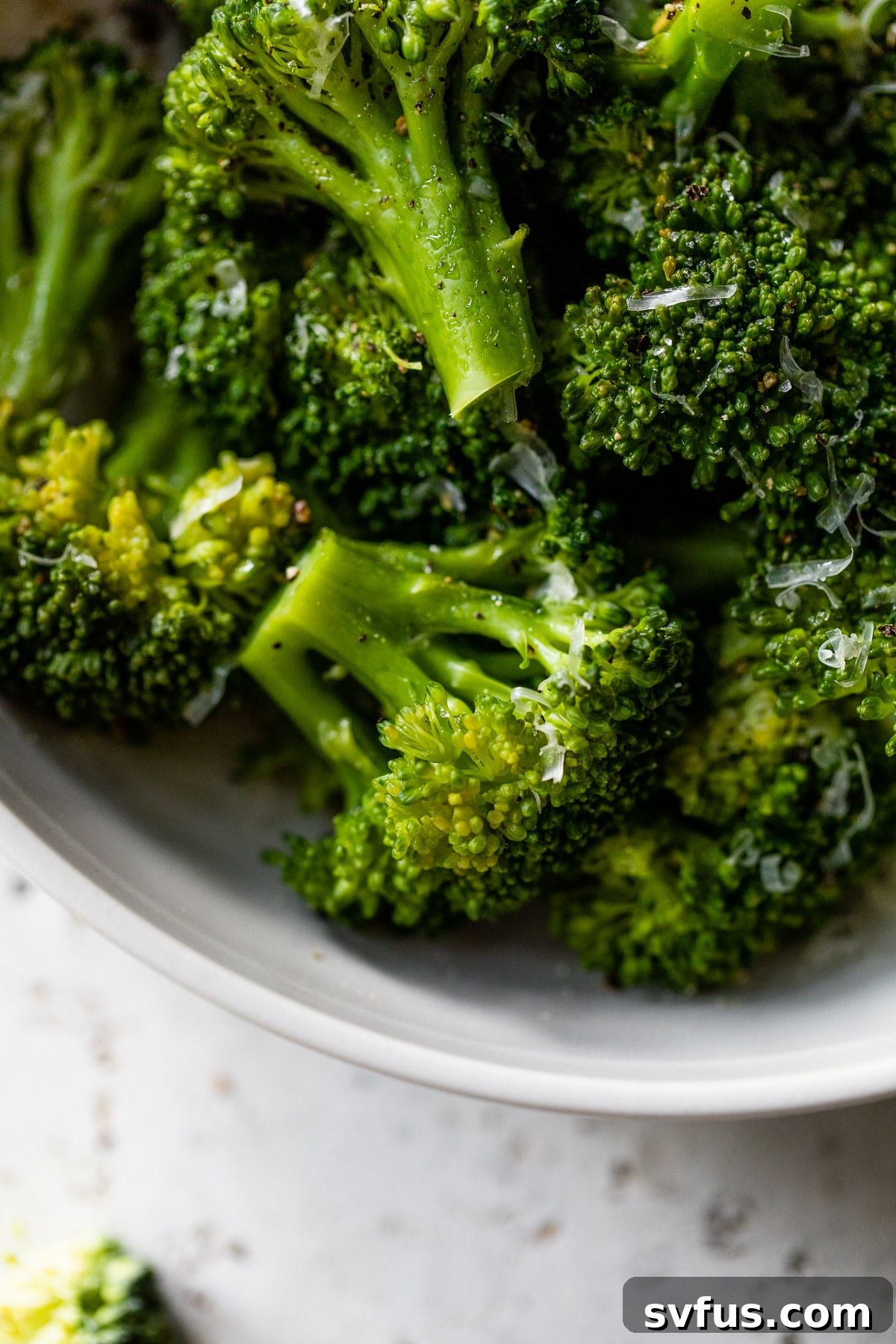 A close-up photograph of perfectly cooked Instant Pot broccoli, showcasing its bright green color and tender, inviting texture, arranged attractively for serving.