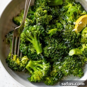 A large bowl of perfectly cooked Instant Pot broccoli, sprinkled with grated cheese, ready to serve.