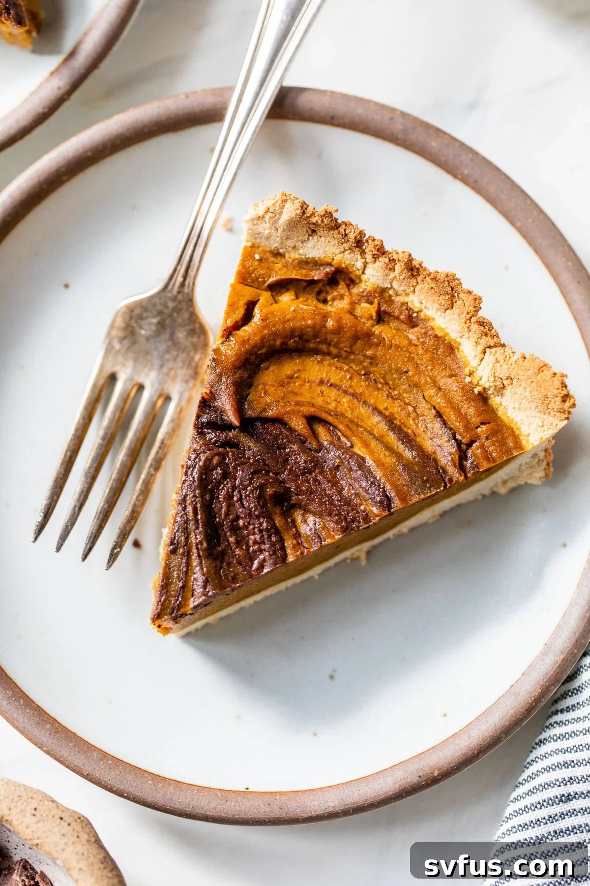 A perfectly baked slice of Paleo Chocolate Pumpkin Pie on a plate with a fork, ready to be enjoyed.