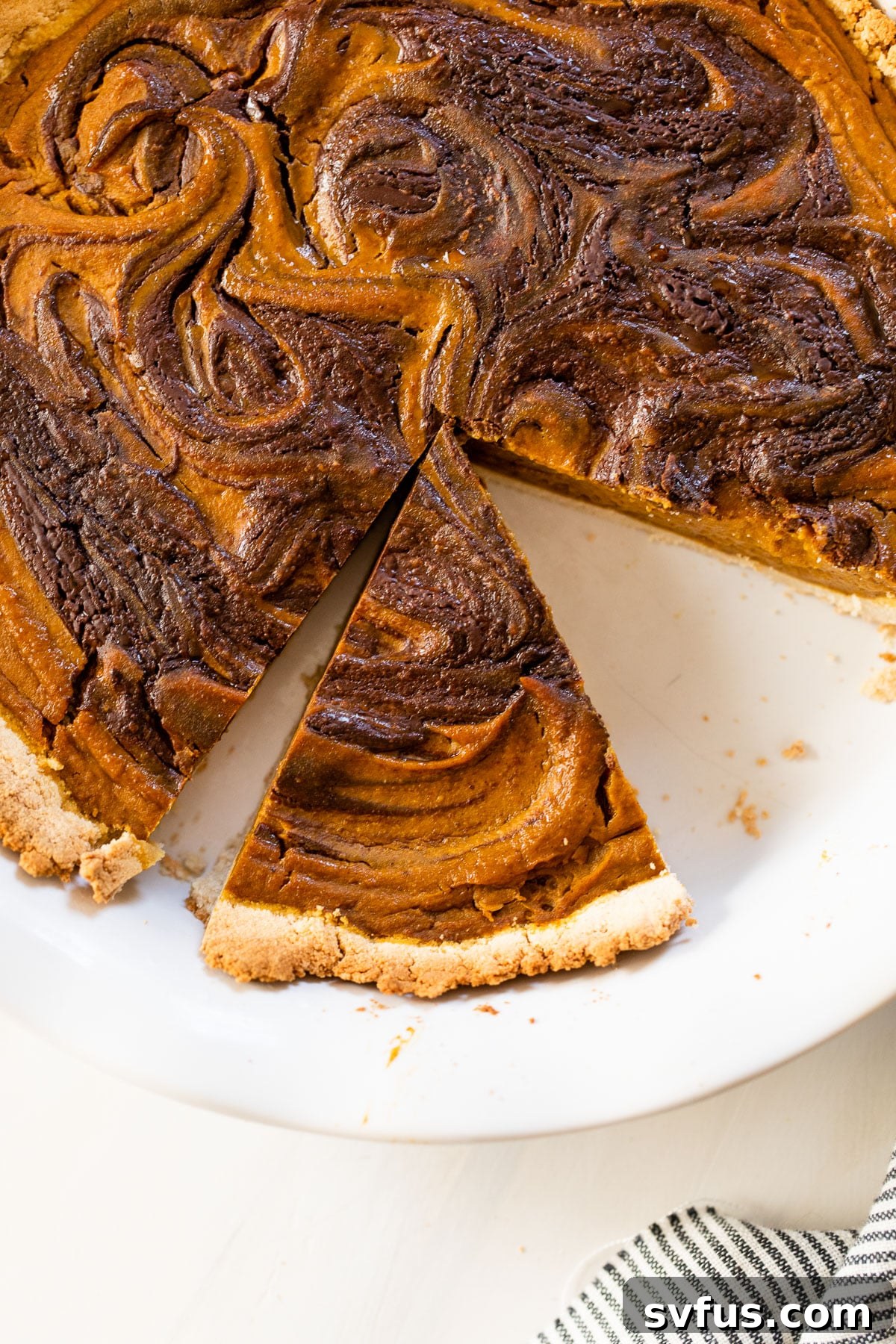 A warm, perfectly baked Paleo Chocolate Pumpkin Pie in a round pie dish, ready to be sliced and served.