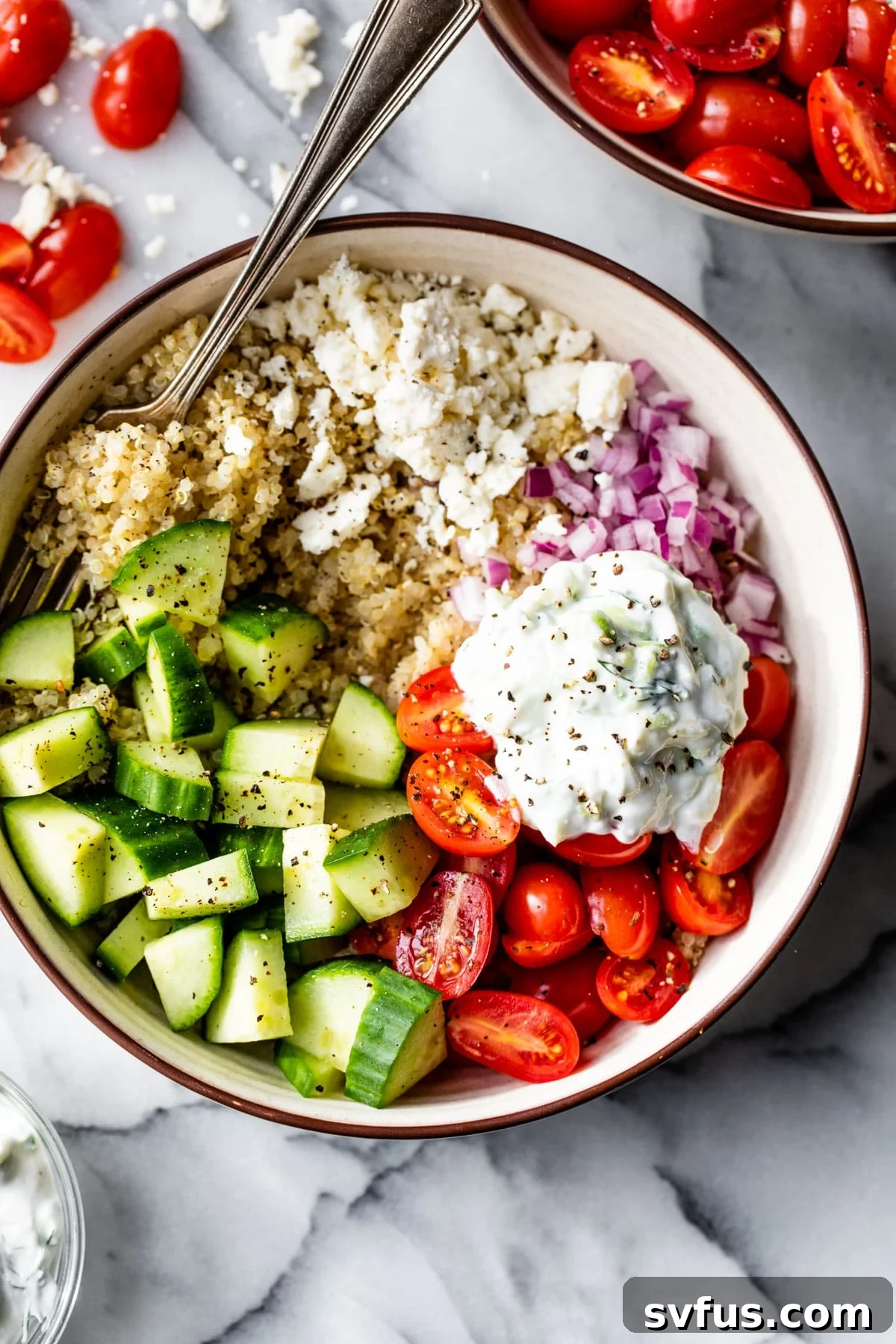 A stunning Mediterranean Quinoa Bowl arranged on a elegant marble table, ready to be enjoyed.