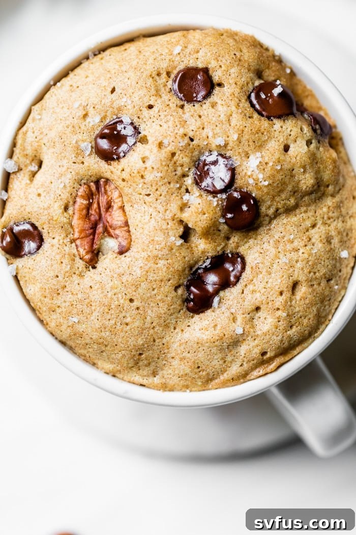 mug cake with chocolate chips and pecans drizzled with maple syrup