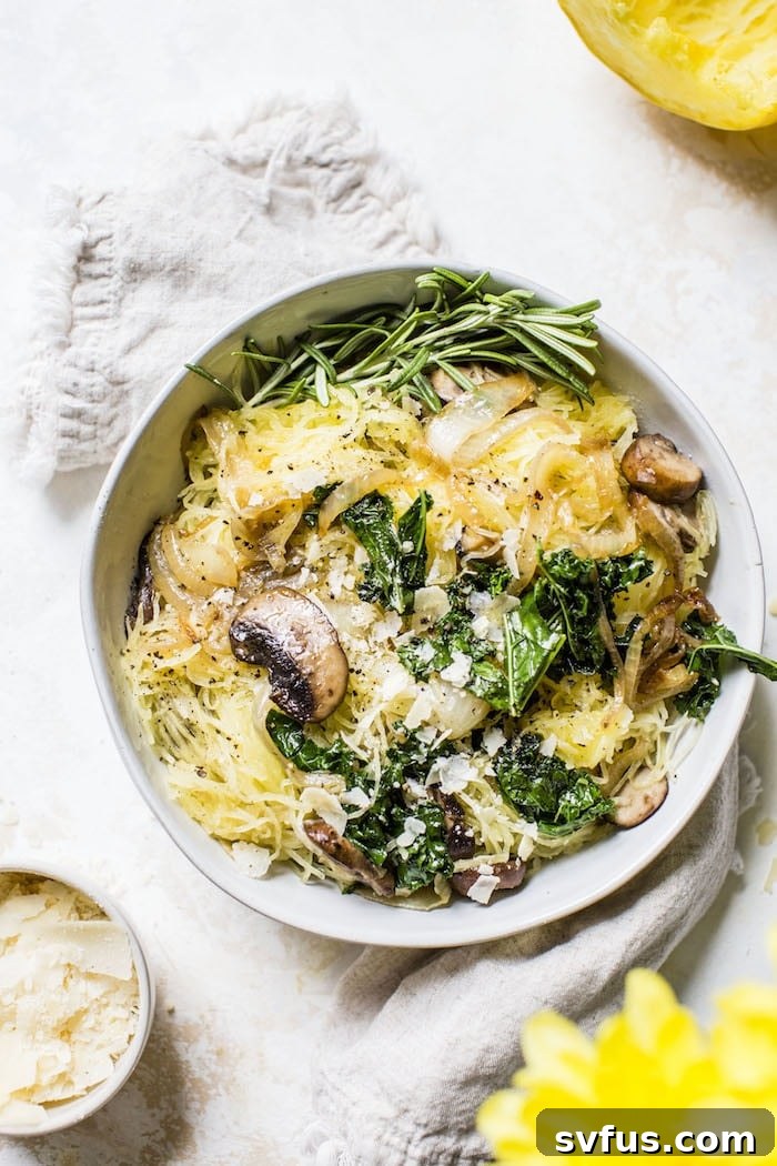 A beautifully presented bowl of spaghetti squash topped with golden caramelized onions, sliced mushrooms, and vibrant green kale, ready to be enjoyed.