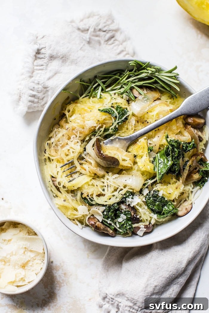 A close-up of the finished Caramelized Onion Spaghetti Squash in a skillet, showcasing the intertwined strands with rich, golden vegetables and herbs.