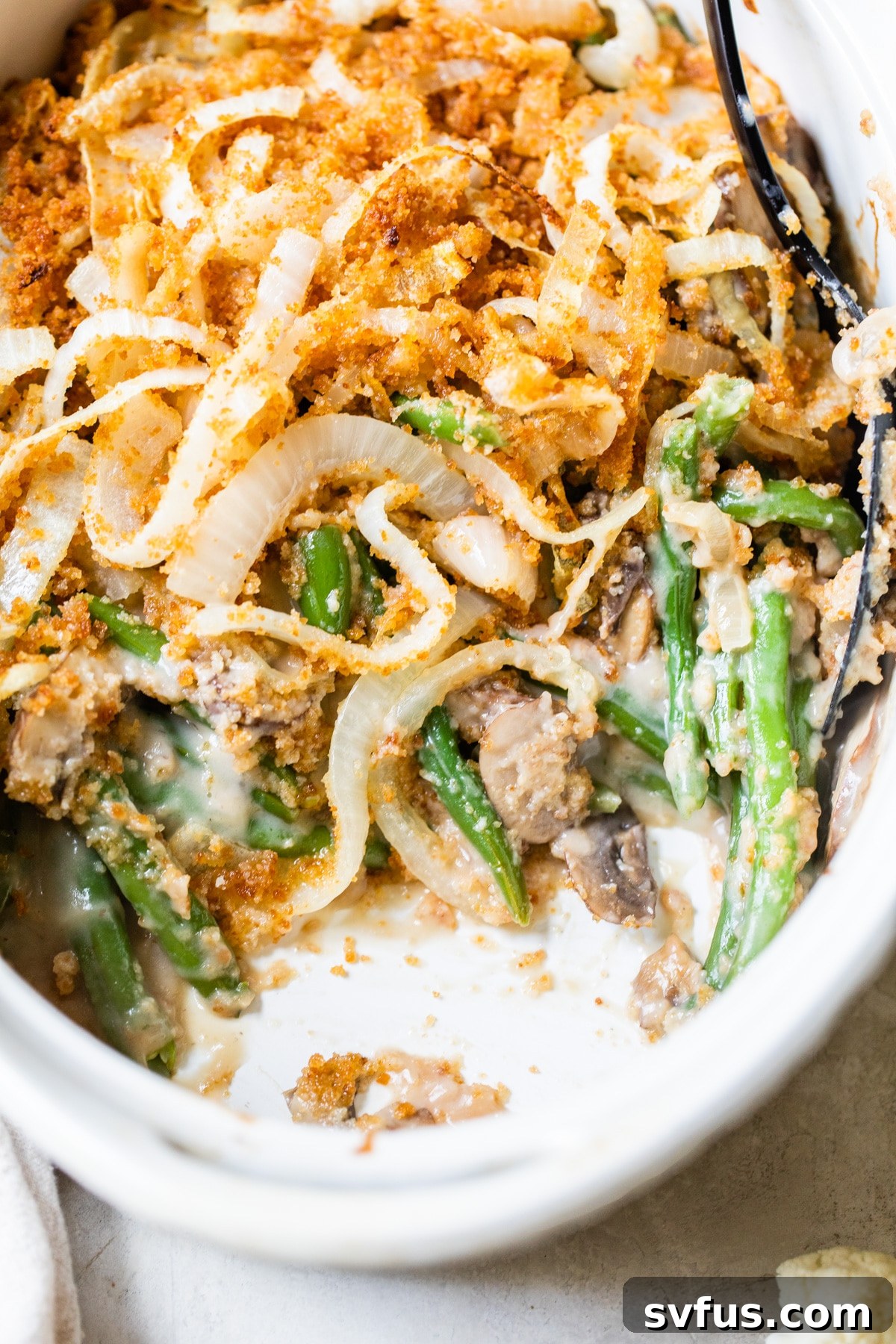 Finished green bean casserole in an oval baking dish, fresh out of the oven.