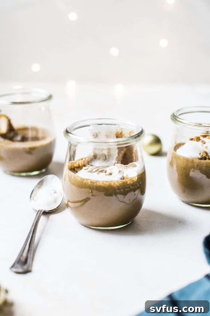 Finished healthy gingerbread mousse in a jar, garnished with dairy-free whipped cream and a sprinkle of cinnamon.