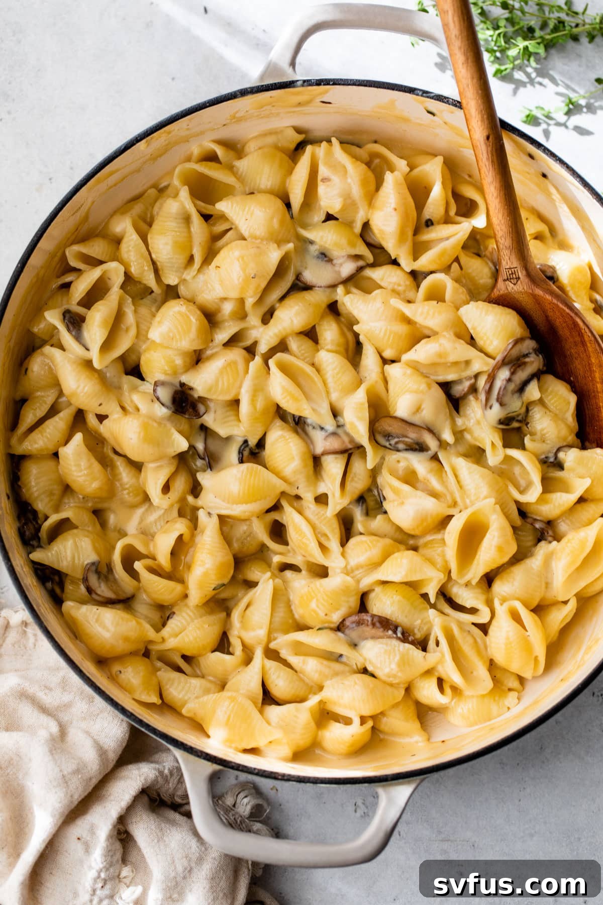 Overview of the finished Truffle Mac and Cheese in a Dutch oven, served with a wooden spoon