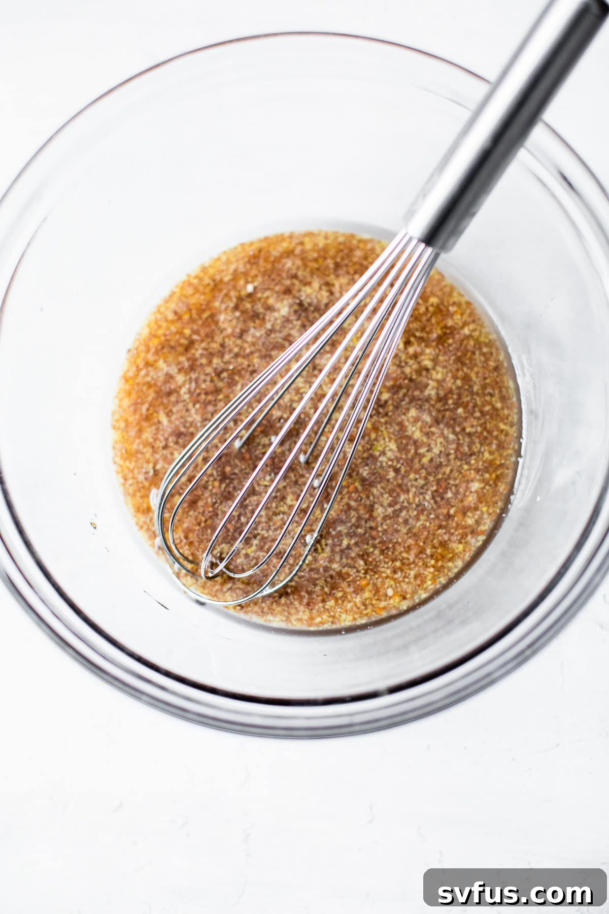 whisked flax egg, coconut oil and maple syrup in a bowl, ready to be combined