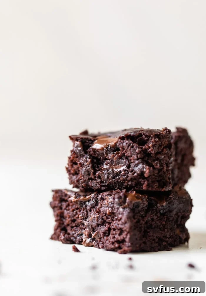 Stack of rich, fudgy black bean brownies with chocolate chips, perfect for a gluten-free dessert.