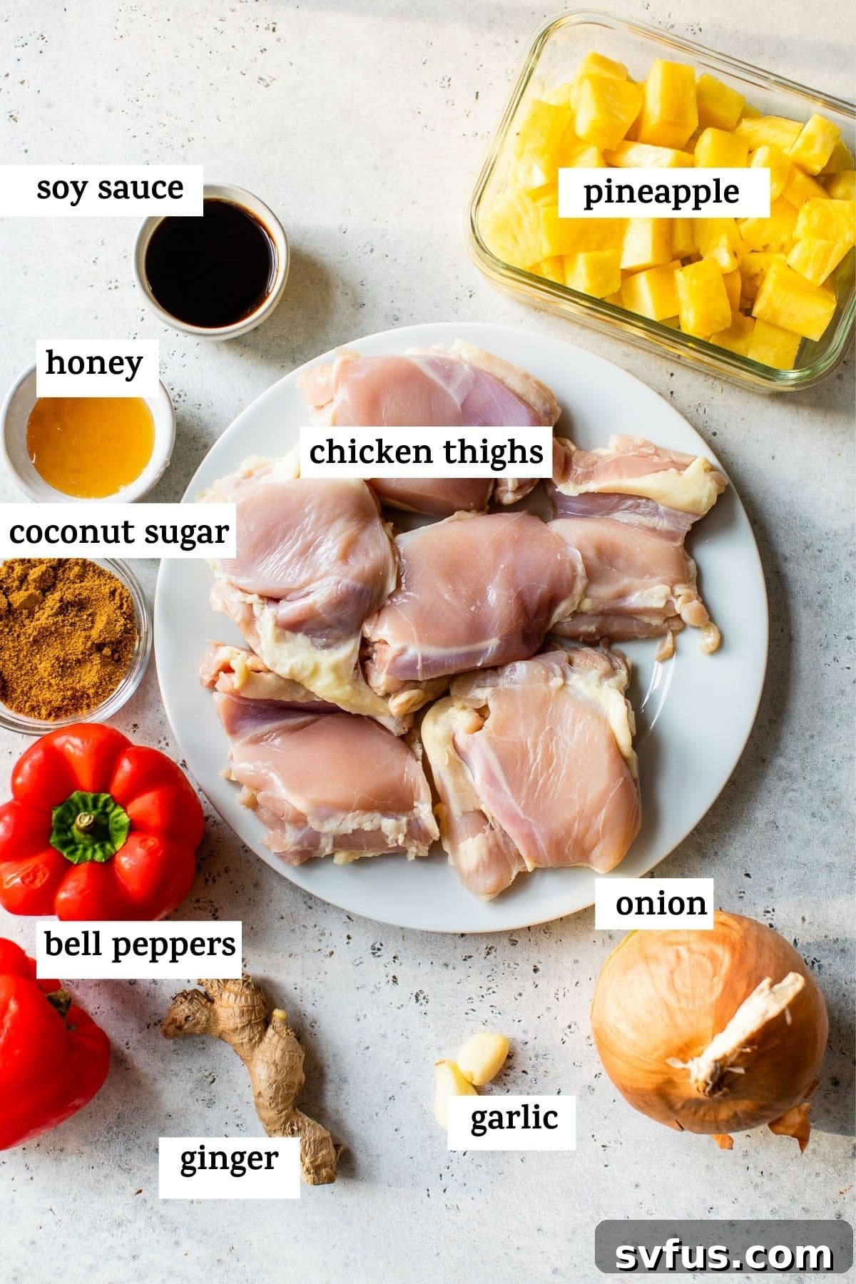 A flat lay image displaying all the fresh ingredients needed to make Crockpot Hawaiian Chicken, including chicken thighs, pineapple, bell peppers, and various sauces.