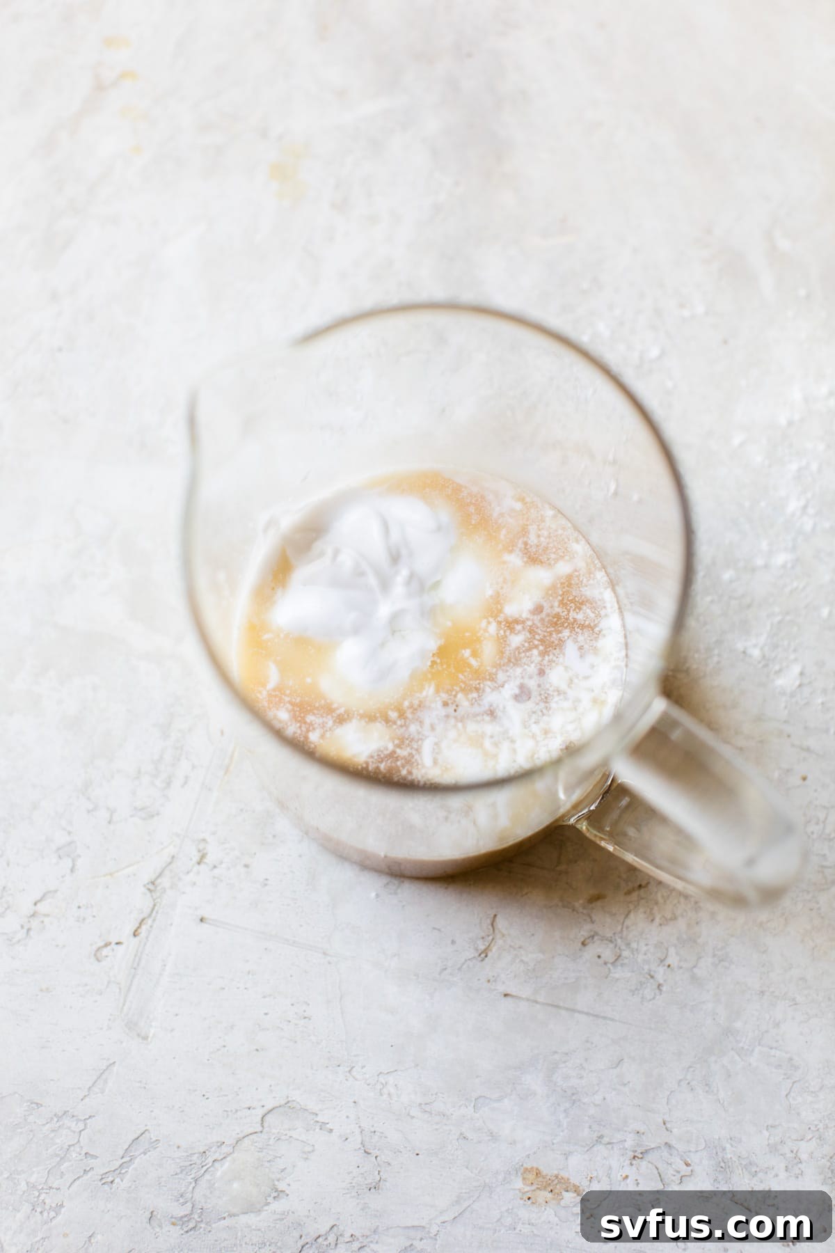 coconut milk and chicken broth being whisked in a cup