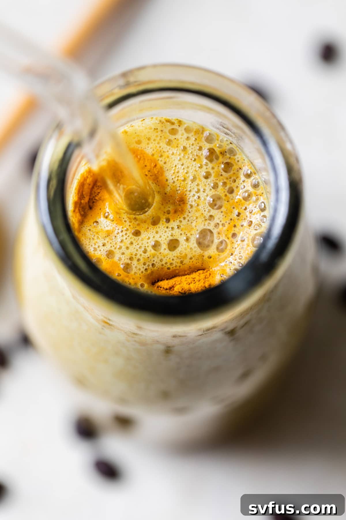 overhead photo of a yellow smoothie in a glass jar