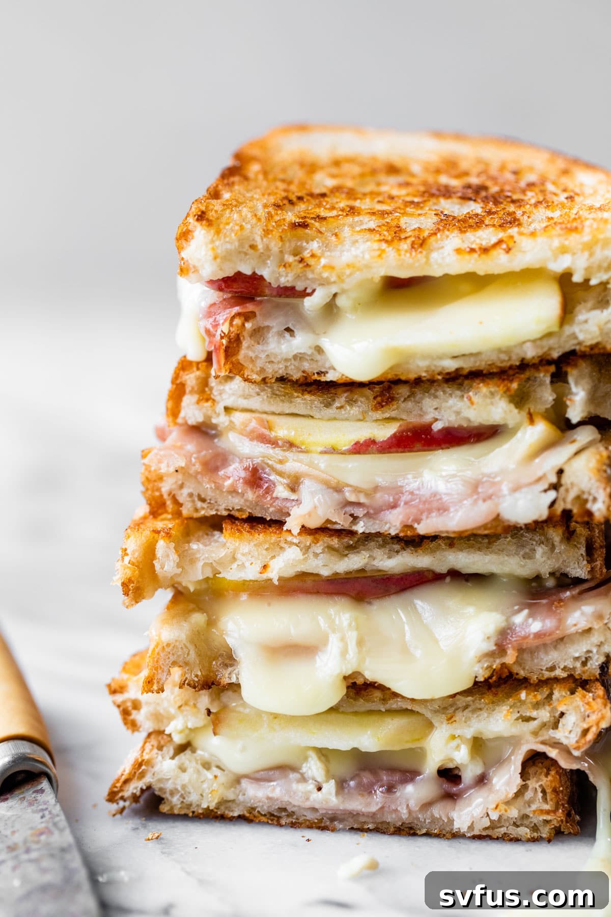 Two delicious brie grilled cheese sandwiches stacked on top of each other, ready to be served.