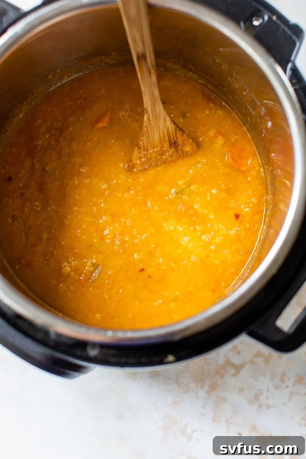 The Instant Pot lid open, revealing perfectly cooked red lentil soup, ready for the final touches.
