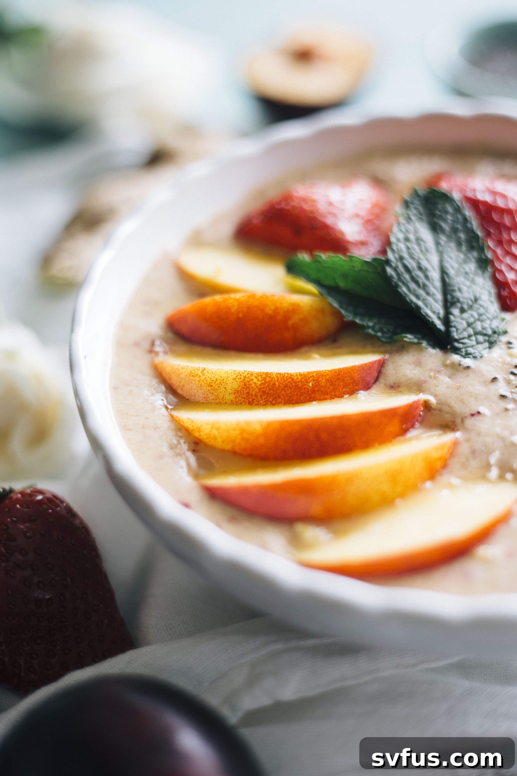 Overhead shot of Nectarine Ginger Smoothie Bowl in a white bowl, ready to be enjoyed as a wholesome breakfast