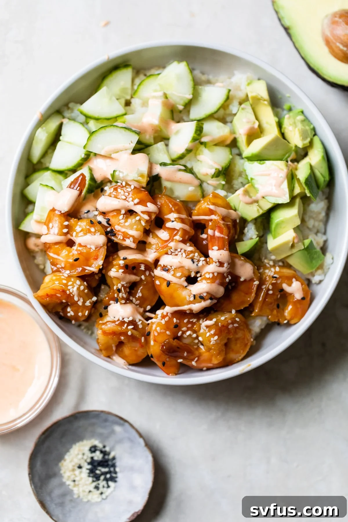 A beautifully assembled Teriyaki Shrimp Sushi Bowl, featuring cooked shrimp, fresh cucumber slices, and creamy avocado, ready for a delicious meal.