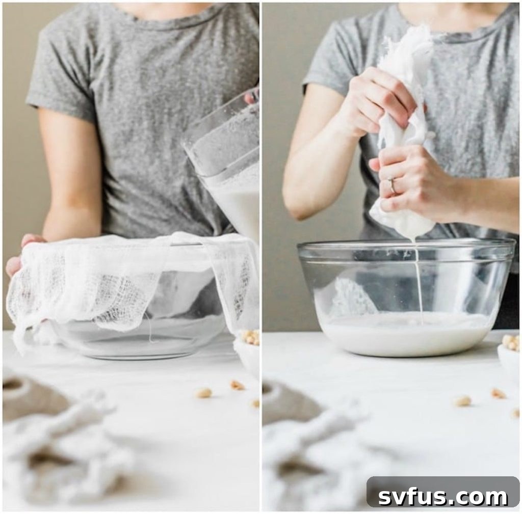 Hands gently squeezing a nut milk bag filled with peanut pulp into a bowl, separating the milk.