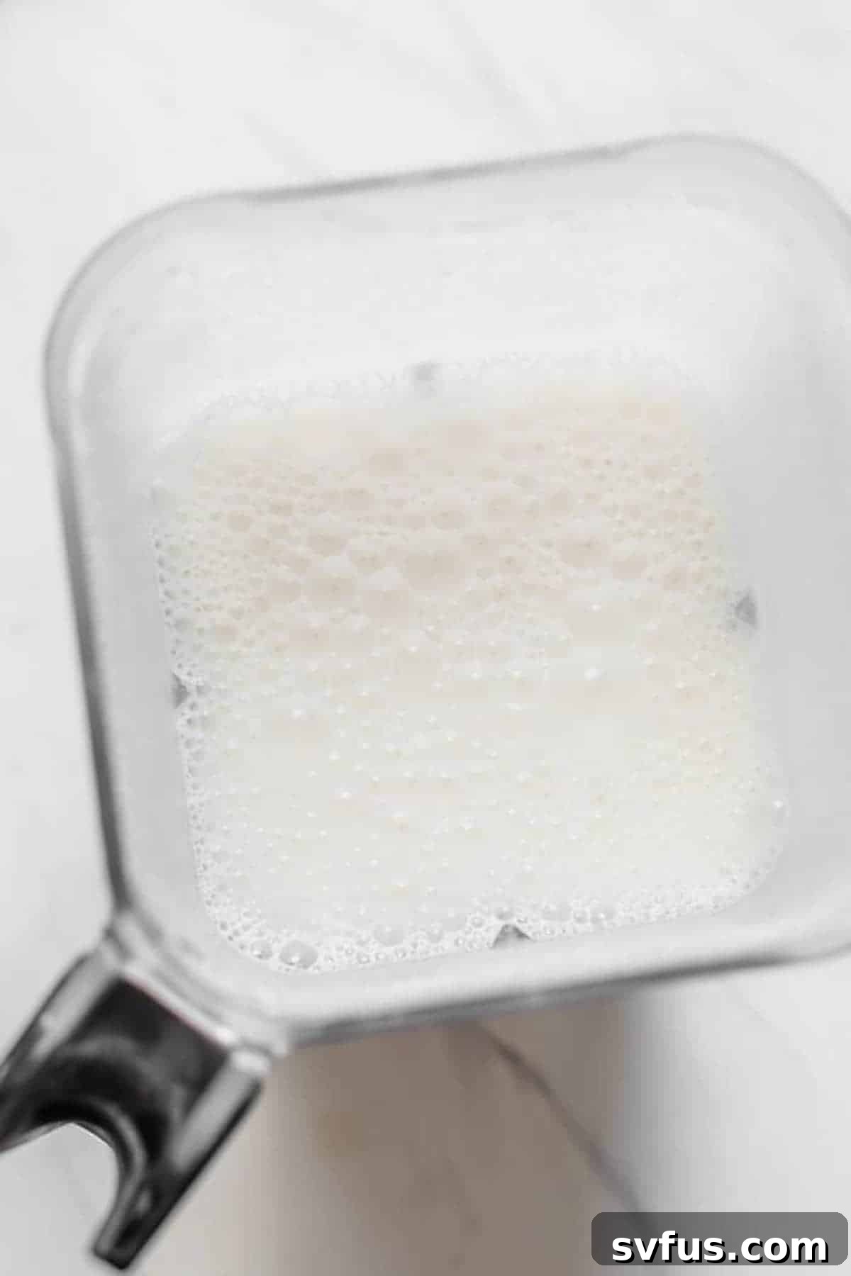 Freshly blended homemade peanut milk in a blender before straining.