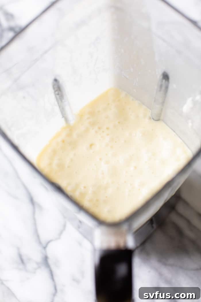 All ingredients for a Piña Colada Smoothie loaded into a high-speed blender, ready to be processed into a smooth, creamy drink.