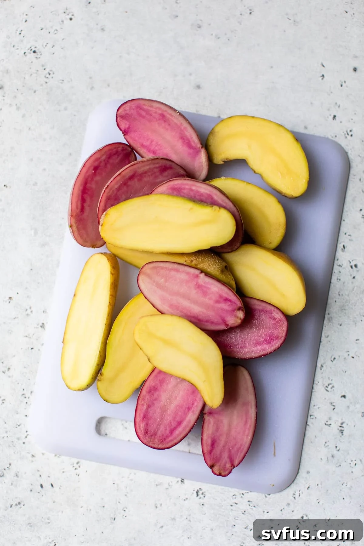 fingerling potatoes sliced in half on a wooden cutting board