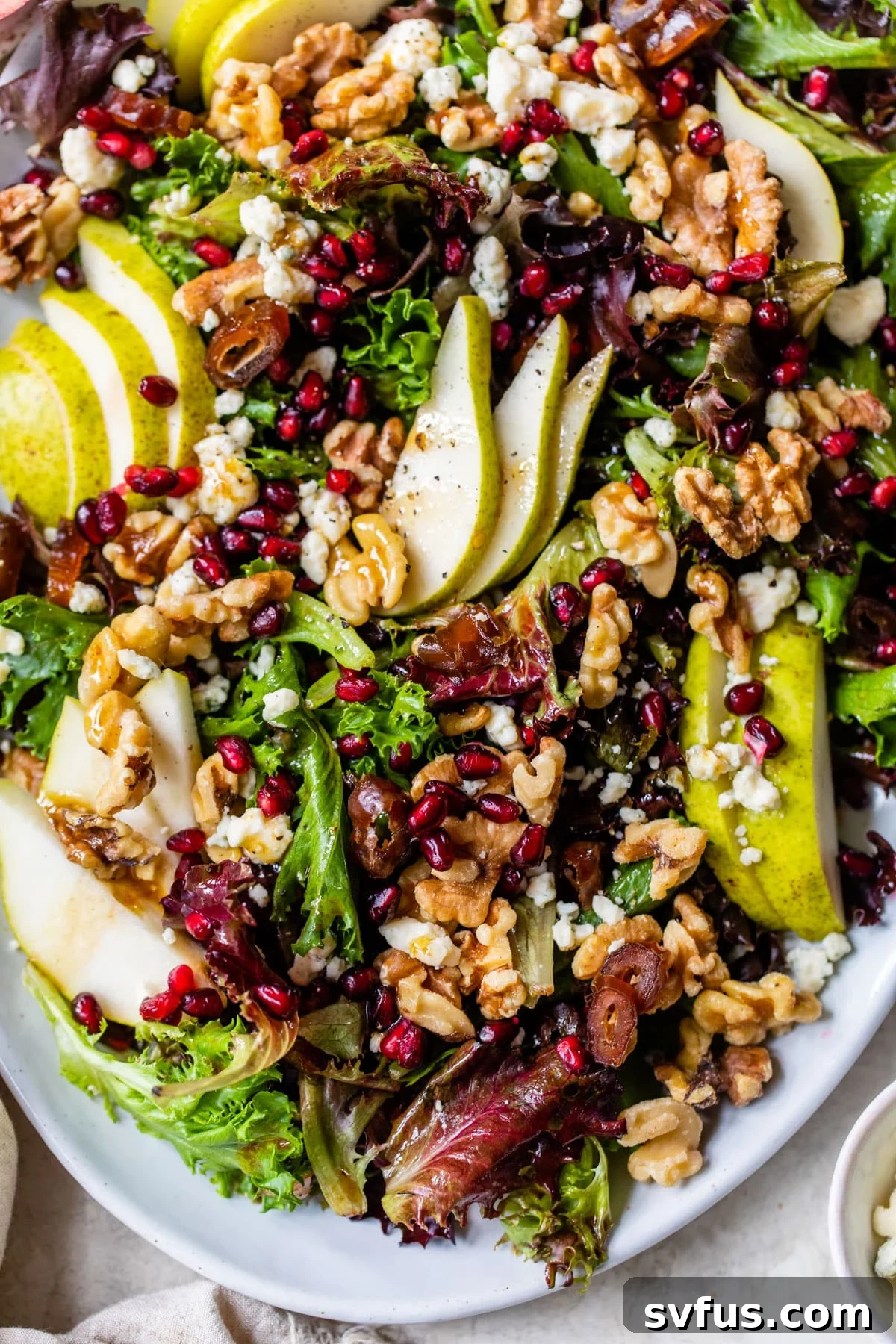 salad on a platter with pear, walnuts and pomegranate