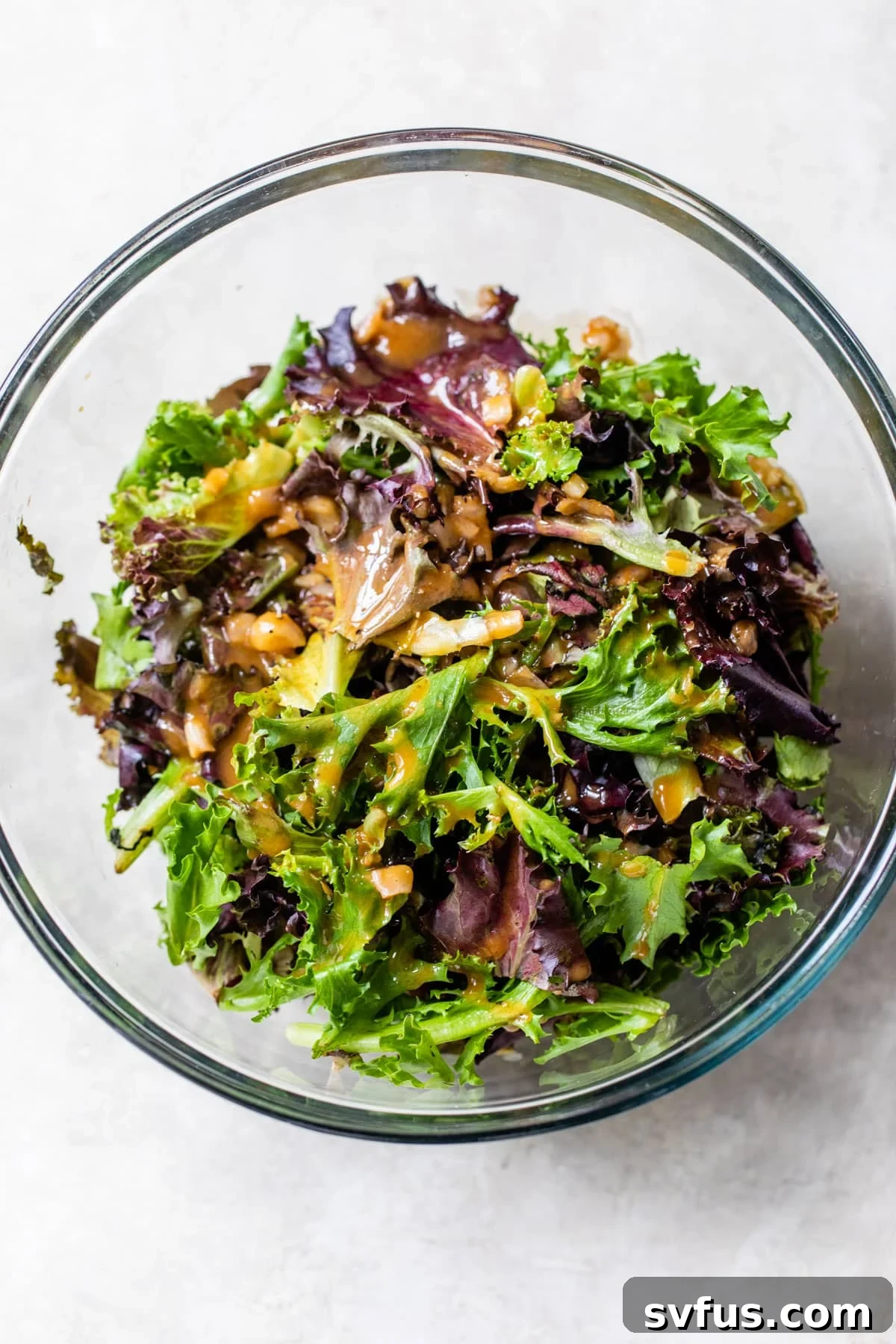 mixed greens in a bowl topped with balsamic viniagrette