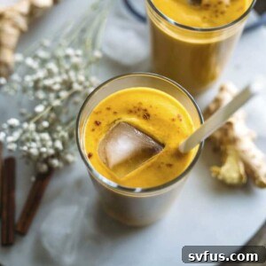 Ginger Pumpkin Smoothie, a vibrant orange drink in a glass with a pumpkin backdrop.