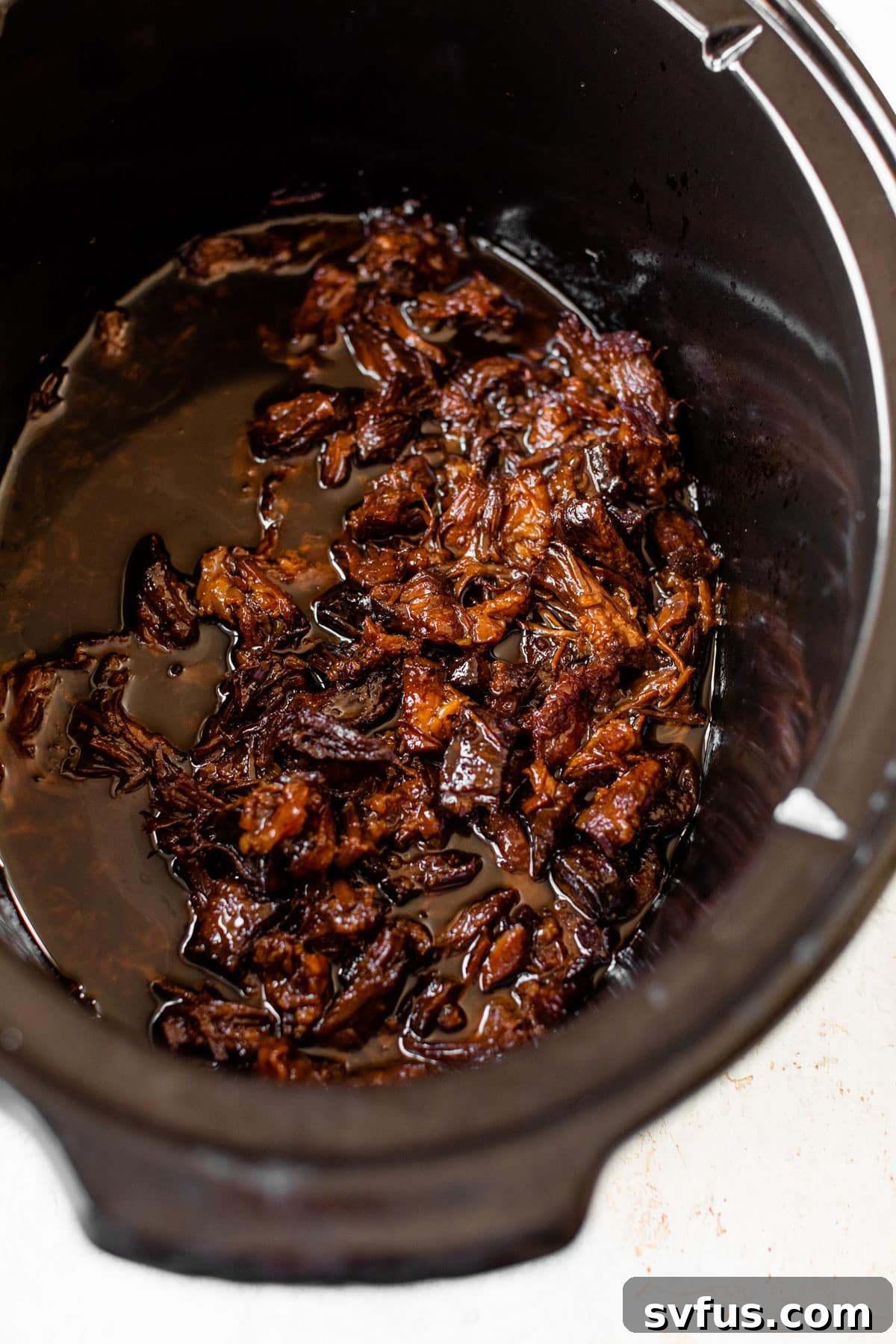 slow cooker filled with marinated pulled pork
