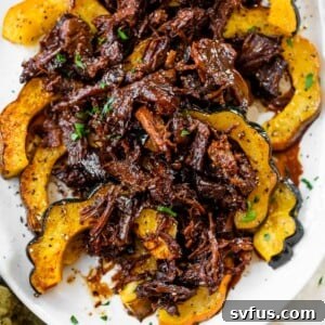 a platter of roasted acorn squash topped with marinated pulled pork