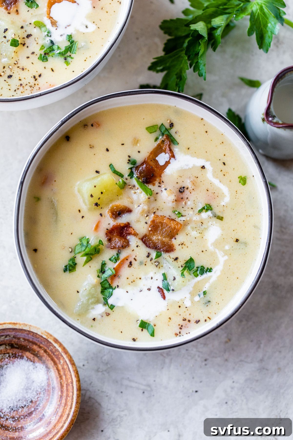 A close-up shot of a rustic bowl filled with creamy potato barley soup, topped with crispy bacon and a sprinkle of fresh parsley, inviting a spoonful.