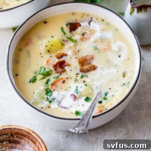 A bowl of creamy potato barley soup, garnished with crispy bacon bits.