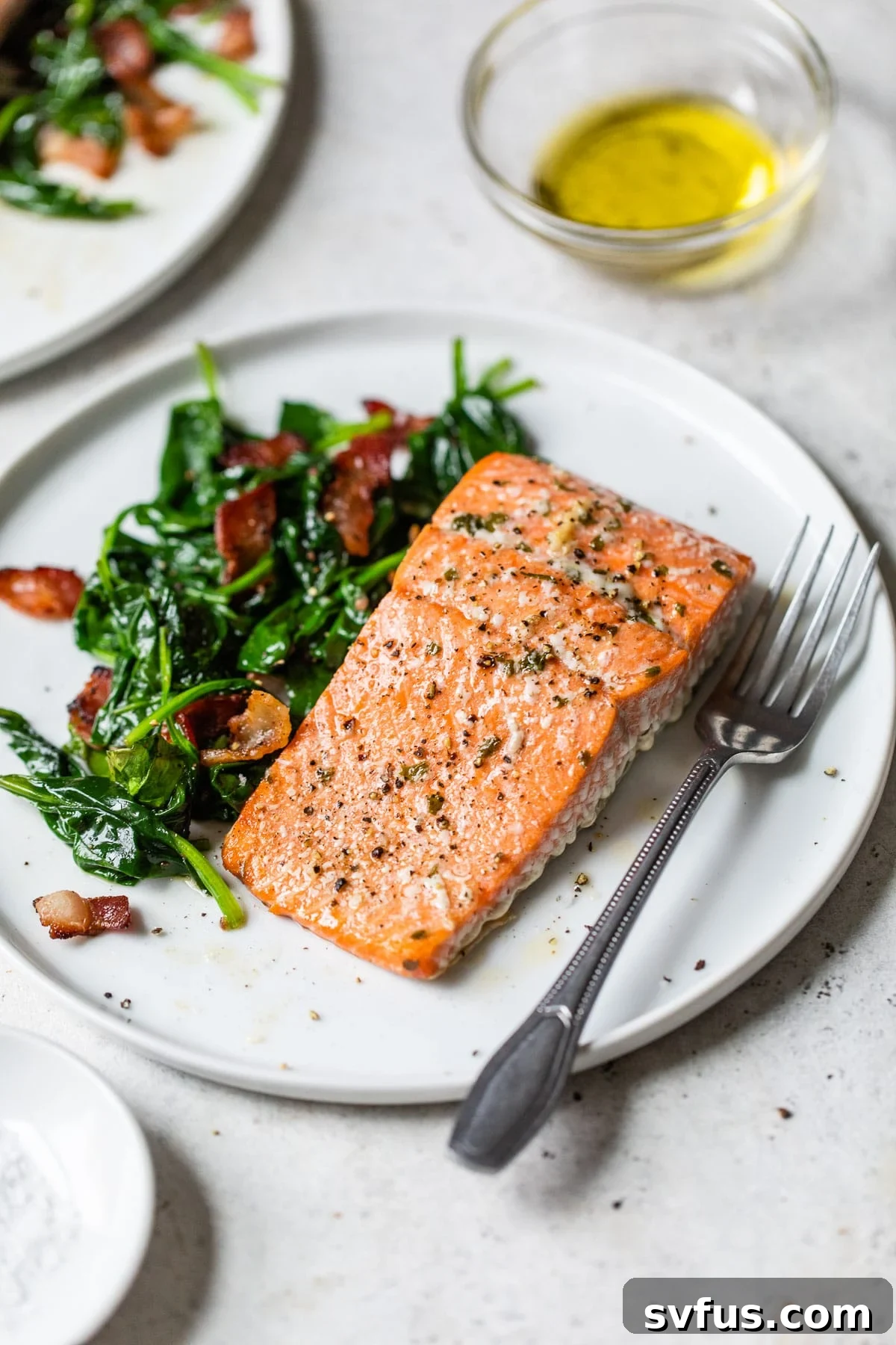 cooked salmon fillet on a plate with spinach