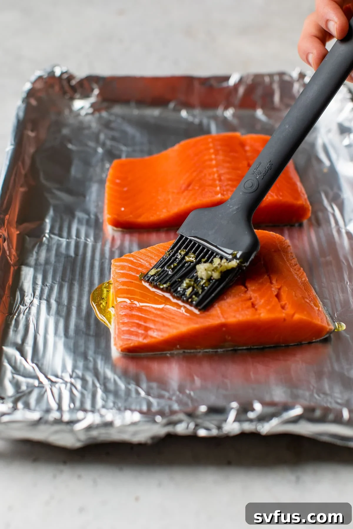 salmon fillet being brushed with olive oil
