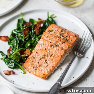 cooked salmon fillet on a plate with spinach