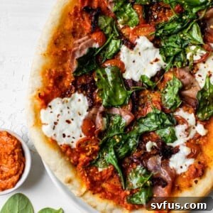 pizza topped with pesto, cheese and prosciutto