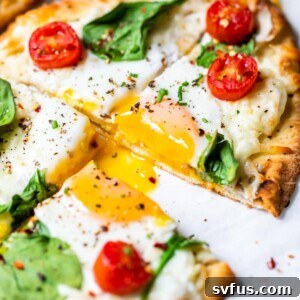Sliced Mini Breakfast Pizza with a perfectly cooked egg and runny yolk