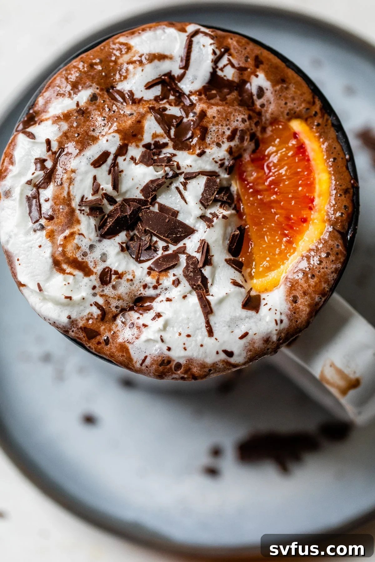 a glass of hot chocolate with whipped cream and chopped chocolate